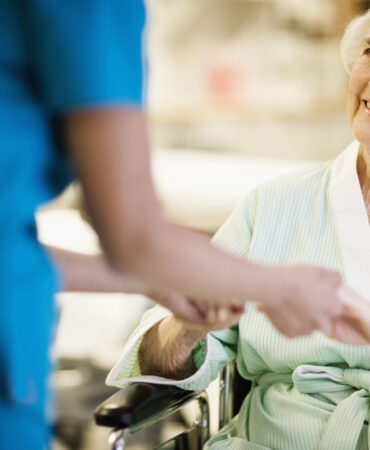 Nurse Holding Hands with Elderly Patient